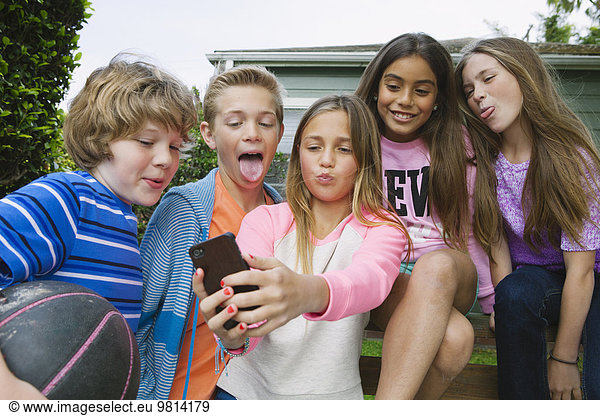 Group of friends taking selfie with smartphone