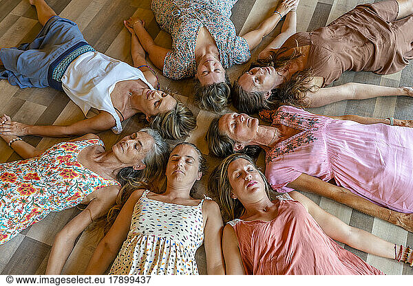 Group of friends with eyes closed lying together on floor