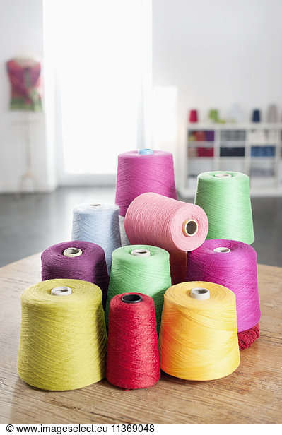 Group of multicolor reels of sewing thread on table
