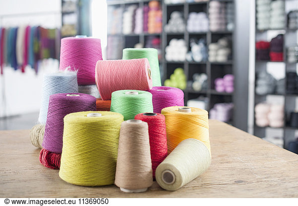 Group of multicolor reels of sewing thread on table