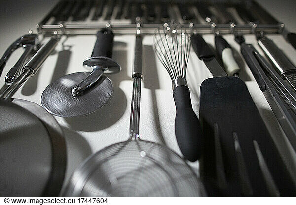 Group of Organized Kitchen Tools Hanging on Home Kitchen Wall