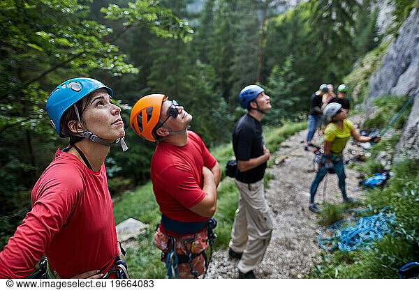 group of rock climbers looks up attentively