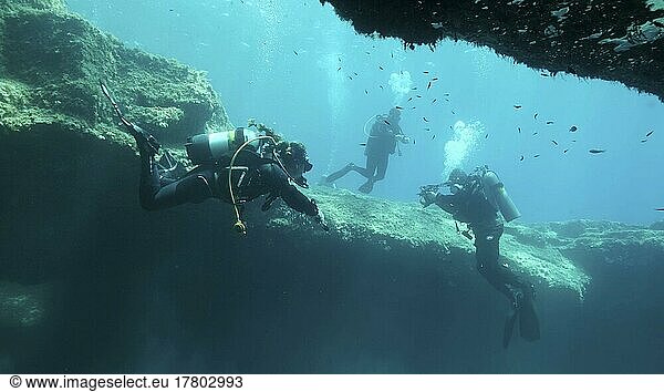 Group of scuba divers swim in the cave. Cave diving in Mediterranean Sea  Cyprus  Europe