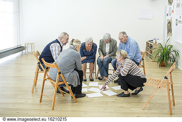Group of seniors in retirement home evaluating result of group therapy