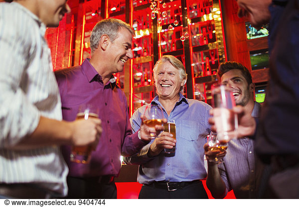 Group of smiling men having drink in bar