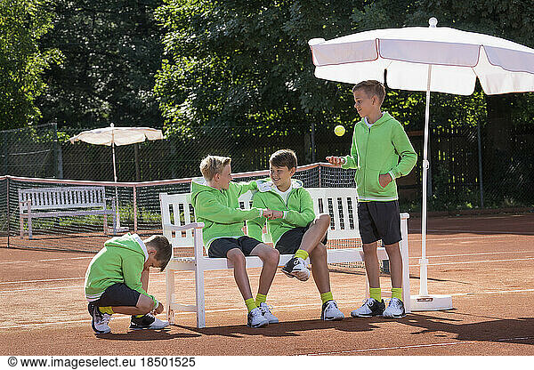Group of young boys relaxing on tennis court  Bavaria  Germany
