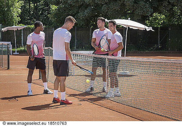 Group of young men playing tennis on a sunny day  Bavaria  Germany