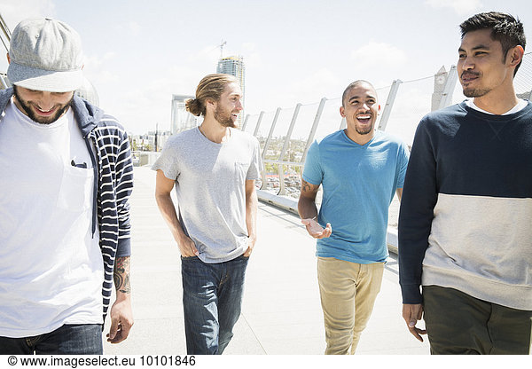 Group of young men walking along a bridge.