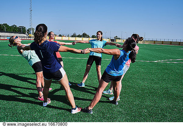 group of young women practice stretching after their training