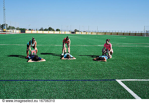 group of young women practice stretching after their training