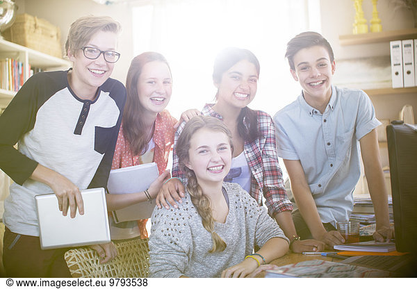 Group portrait of smiling teenagers at home