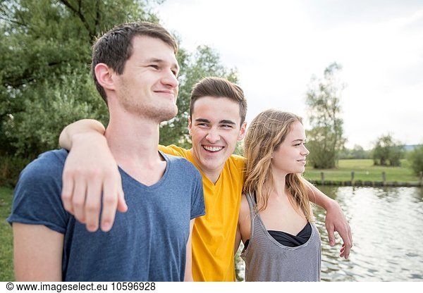 Gruppe junger Erwachsener  am See stehend  lächelnd