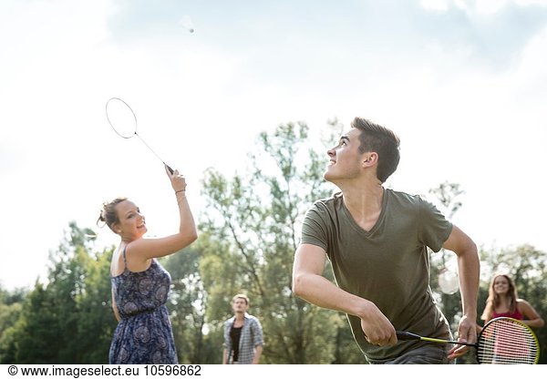 Gruppe junger Erwachsener beim Badmintonspiel im Feld