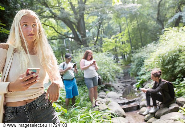 Gruppe von Freunden spielt Augmented-Reality-Spiel mit Handys im Park
