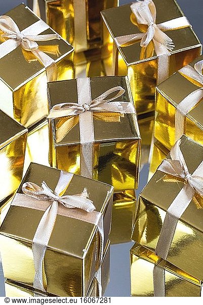 Gruppe von Gold funkelnden Geschenk-Boxen auf grauem Hintergrund mit Reflexion. Eine Reihe von Gold-Geschenk-Boxen für Geschenk  suprise  Geburtstag  Weihnachten Konzept Schönheit.
