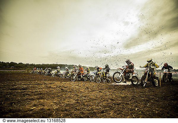 Gruppe von Jungen auf Motorrädern an der Motocross-Startlinie