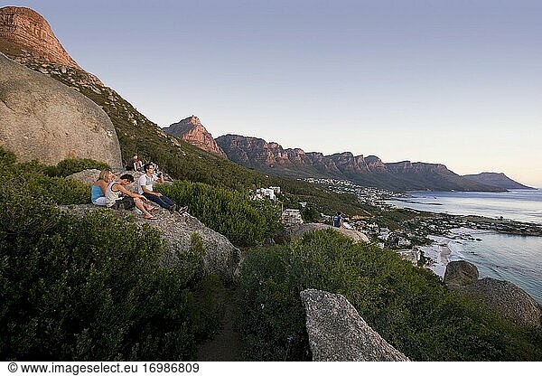 Gruppe von Menschen mit Blick auf den Sonnenuntergang Blick auf die Zwölf Apostel Bergkette  Kapstadt  Südafrika