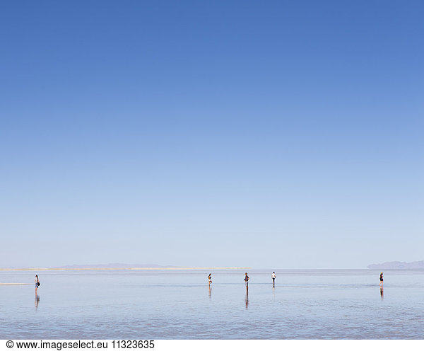 Gruppe von Menschen steht auf überfluteten Bonneville Salt Flats  Utah