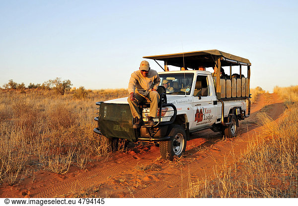 Guide vom Stamm der Khomani-Buschleute  Khomani-San  beim Spurenlesen auf einem Safari-Fahrzeug der !Xaus Lodge  Kgalagadi Transfrontier Park  Kalahari  Südafrika  Afrika