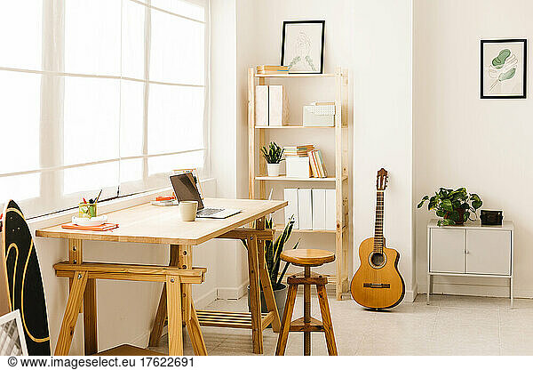 Guitar by bookshelf in living room at home