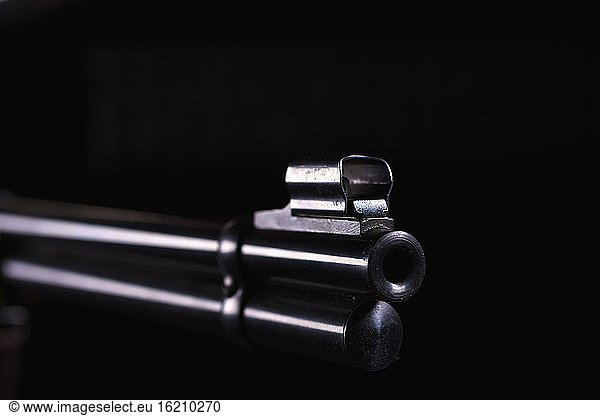 Gun barrel against black background  close up