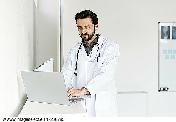 Gut aussehender männlicher Arzt mit Laptop im Krankenhaus
