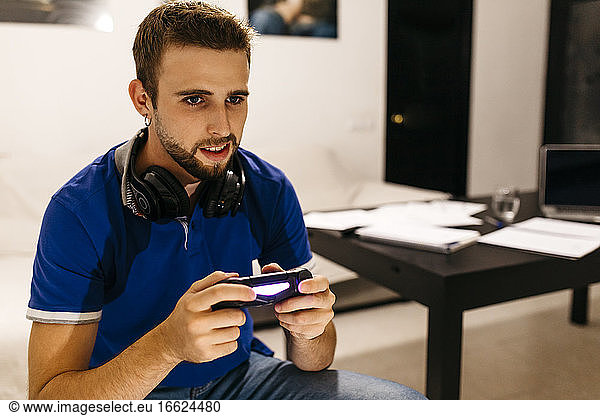 Gut aussehender Mann  der zu Hause ein Videospiel spielt