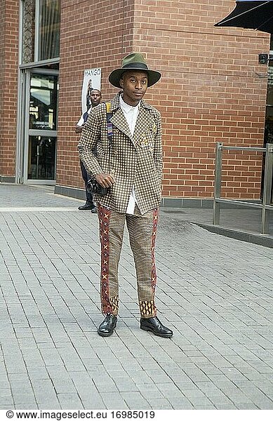 Gut gekleideter afrikanischer Mann mit Kamera auf der südafrikanischen Modewoche in Melrose Arch  Johannesburg  Südafrika
