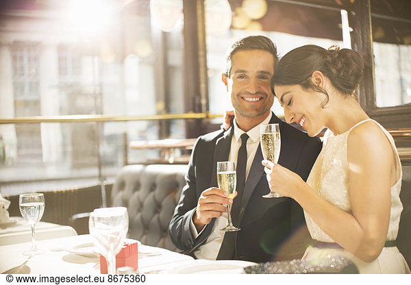 Gut gekleidetes Paar trinkt Champagner im Restaurant