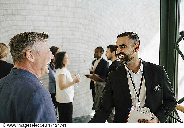 Gut gelaunte Geschäftsleute diskutieren während einer Networking-Veranstaltung im Kongresszentrum