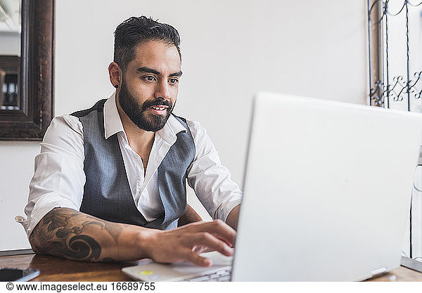 Gutaussehender Mann  gekleidet als Manager  arbeitet am Laptop