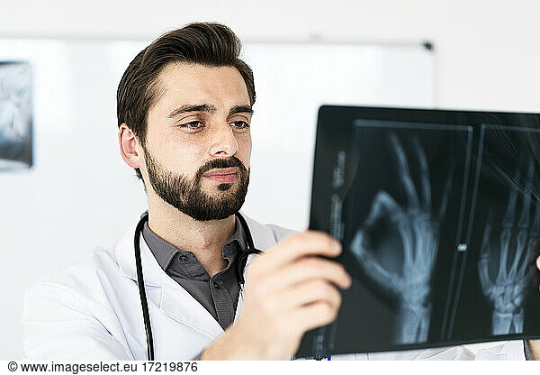 Gutaussehender medizinischer Angestellter bei der Untersuchung von Röntgenbildern