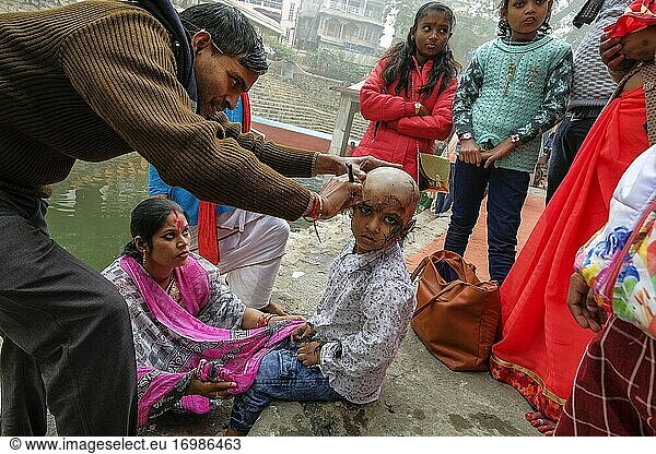 Guwahati  Indien - Januar 2021: Eine Familie feiert am 18. Januar 2021 im Kamakhya-Tempel in Guwahati  Assam  Indien  das Chudakarana-Fest  bei dem ein Junge seinen ersten Haarschnitt erhält.