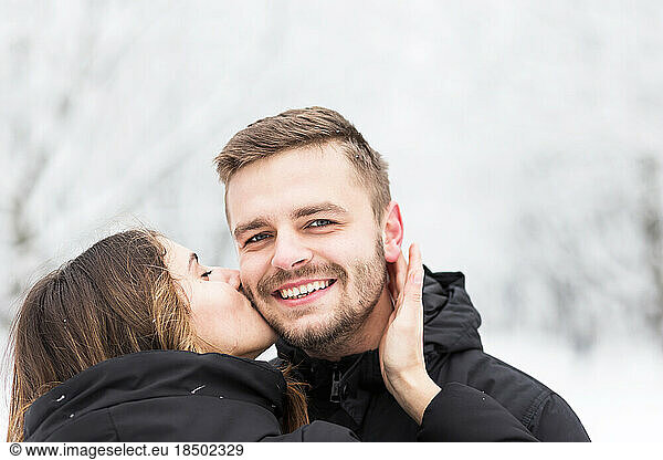Guy and girl hugging themselves in the snowy winter park