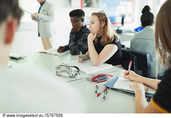 Gymnasiasten lernen an Tischen im Klassenzimmer