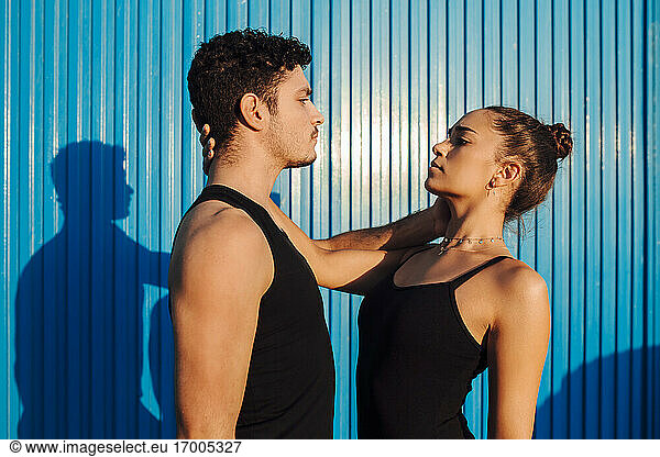 Gymnast young couple looking at each other by blue wall
