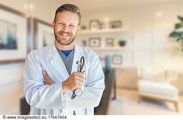 Hübscher junger erwachsener Arzt mit Bart im Büro
