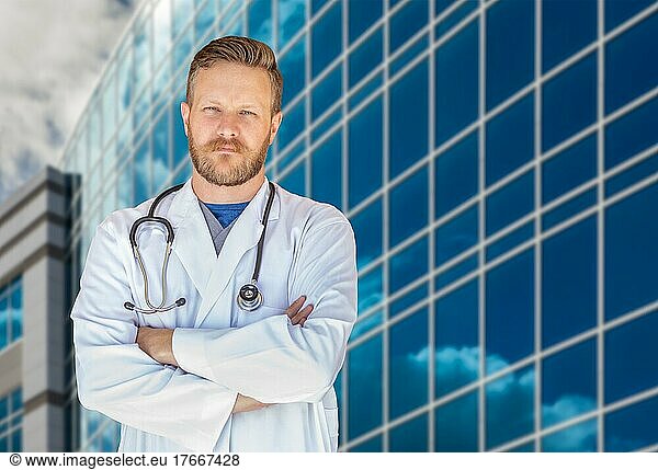 Hübscher junger erwachsener Arzt mit Bart vor einem Krankenhausgebäude