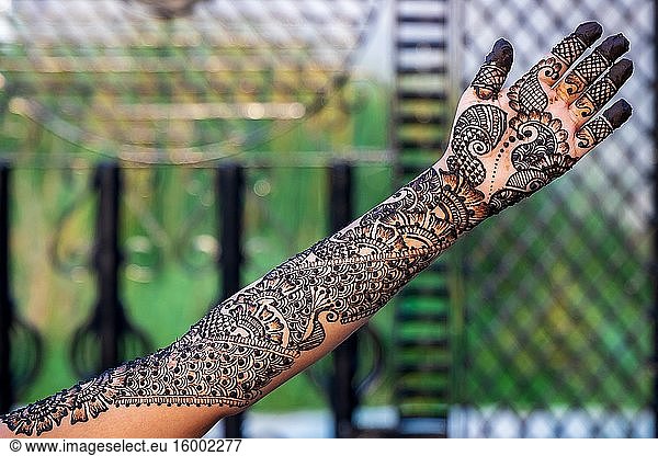 Hände einer Frau mit detaillierter Henna-Malerei.