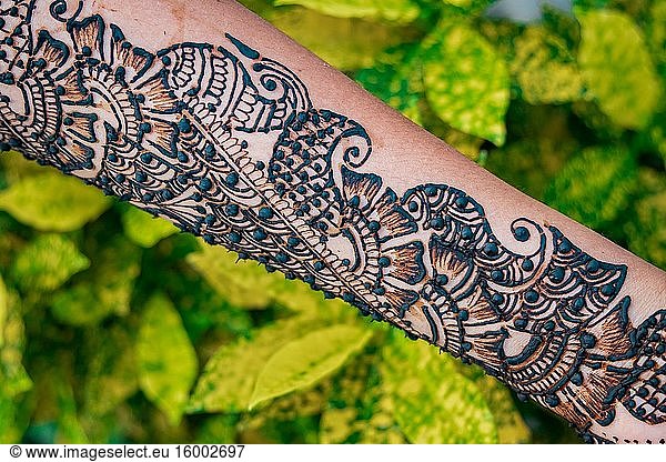 Hände einer Frau mit detaillierter Henna-Malerei.
