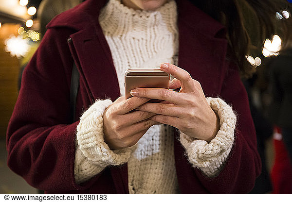 Hände einer jungen Frau  die ein Smartphone hält  Nahaufnahme