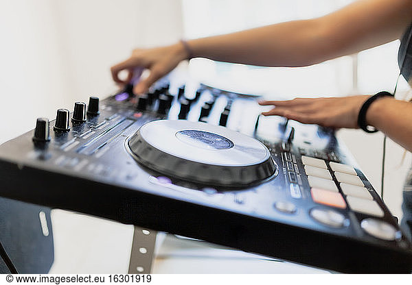 Hände eines weiblichen DJs beim Abmischen von Ton im Aufnahmestudio