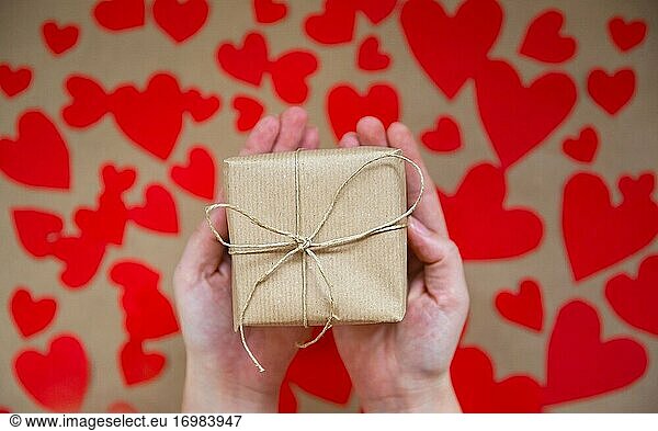 Hände halten schöne Geschenk-Box  weibliche geben Geschenk  Valentinstag  Urlaub und Gruß Saison-Konzept  Draufsicht Hintergrund romantisches Design.