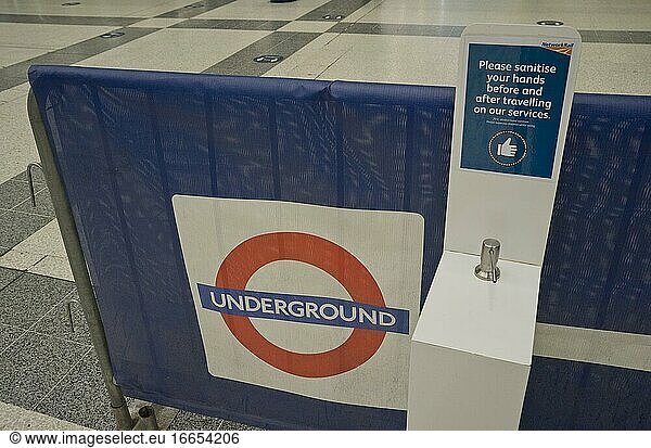 Händedesinfektionsgel in einer Londoner U-Bahn-Station  mit Schildern  die aufgrund der Coronavirus-/Covid-19-Pandemie in London  England  Vereinigtes Königreich  auf einen sicheren Sicherheitsabstand hinweisen.