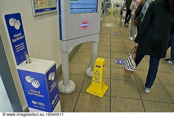Händedesinfektionsmittel in einer Londoner U-Bahn-Station  mit Schildern  die aufgrund der Coronavirus-/Covid-19-Pandemie in London  England  Vereinigtes Königreich  zu einem sicheren Sicherheitsabstand raten.