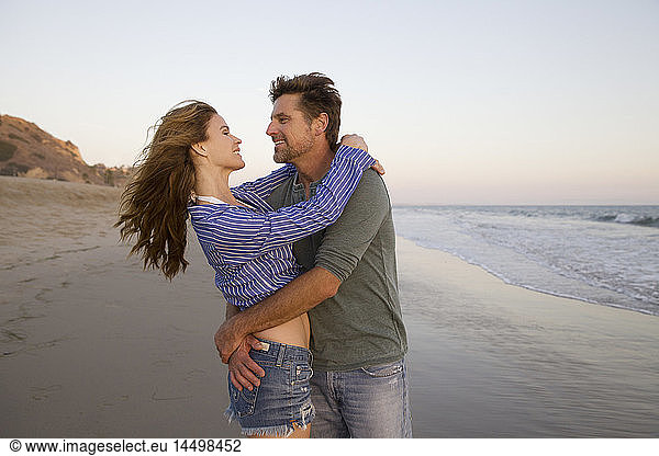 Half-Length Portrait of Romantic Mid-Adult Couple in Each Other's Arms at Beach