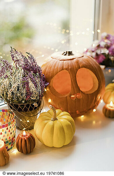 Halloween decorations with lights and carved pumpkins on window sill
