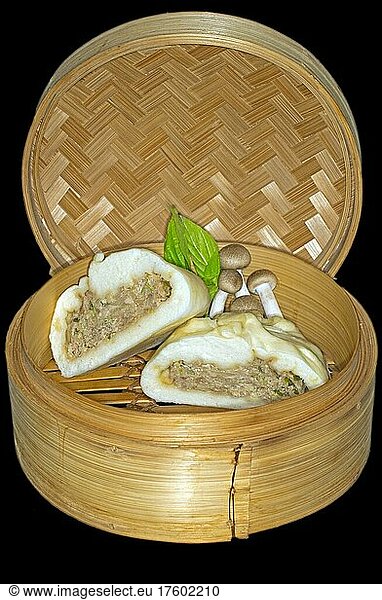 Halved bhan bao stuffed with pork meat and shimeji mushrooms  lying in a bamboo basket