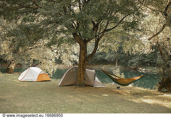 Hammock and tents by the river