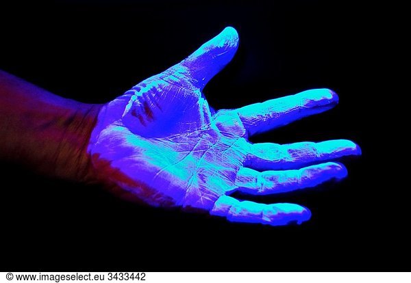 Hand covered in UV sensitive solution under Ultra Violet light source to detect germs and other undesirable materials before proceeding on to hospital ward